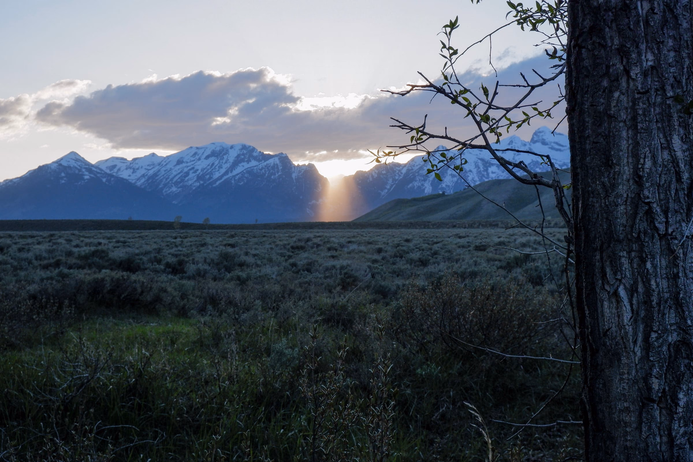 Sun setting behind Grand Teton mountain range seen from Gros Venture Campground.